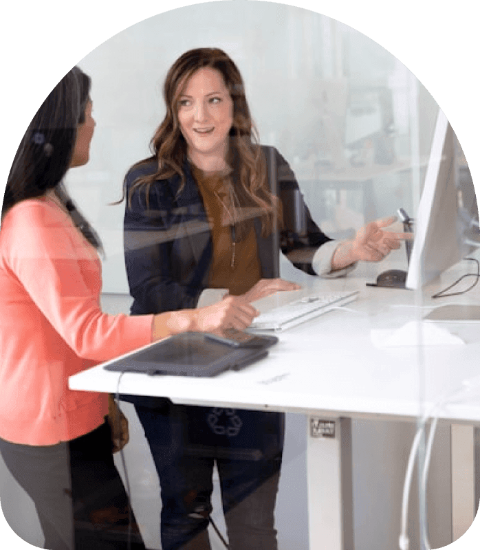 Two colleagues collaborating at a standing desk